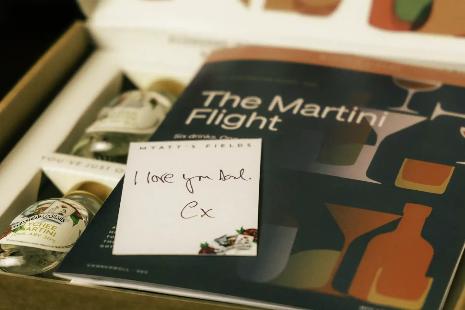 The Martini Flight gift box, open: the six miniatures, the illustrated brochure and a hand-written card